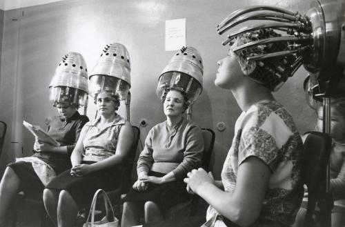Women drying their hair in curlers at salon