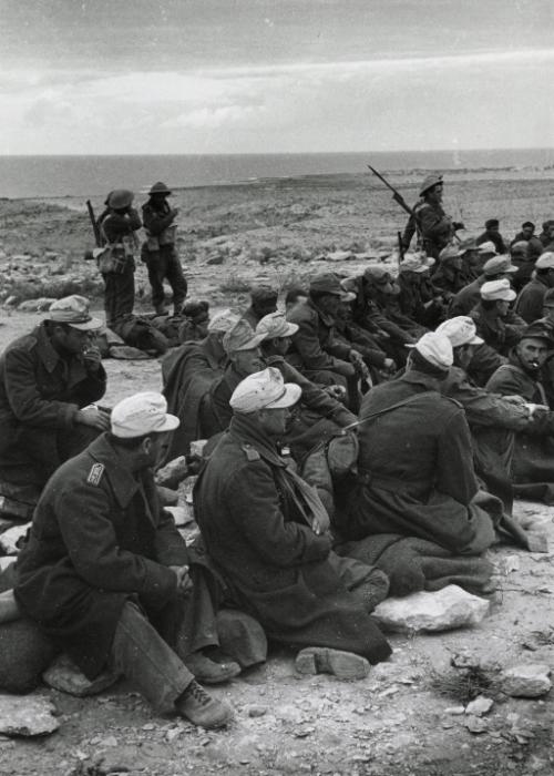 Prisoners, some Italian but mostly German, gathered on higher land, awaiting transport to prison camp, Egypt