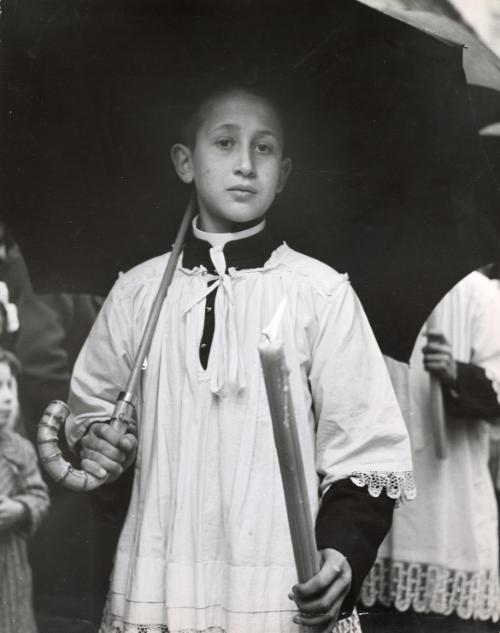 Alter boy walking with candle and umbrella