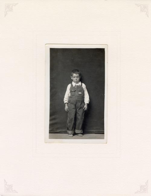Standing boy in overalls