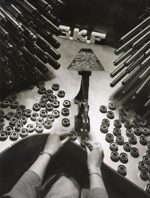 Female hands loading metal balls into bearings