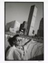 Woman sunbathing against cityscape, New York, from the "Hipshot" series.