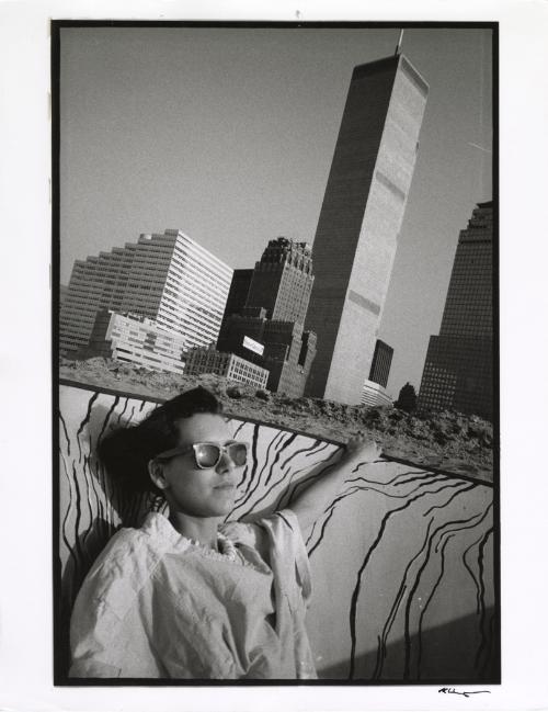 Woman sunbathing against cityscape, New York, from the "Hipshot" series.