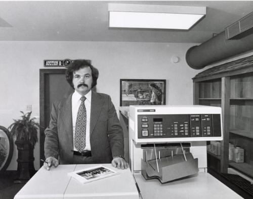 Office worker in front of a Xerox 9200 copy machine, Tri-Valley Area, Northern California, from the series "Working"