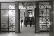 Three men walking toward a doorway, Warsaw, Poland