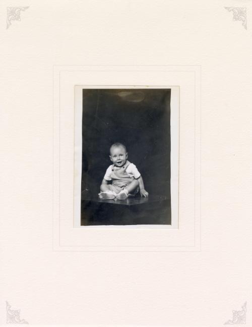 Untitled [smiling baby seated on table]