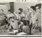 At a news conference in the Federal Building in Chicago. Yippie leader Jerry Rubin makes a point by pounding the desk. He appeared at the conference with six other defendants, charged with conspiracy to incite mob action at the Democratic Convention, who are standing behind him. They are (from left) John Froines, Abbie Hoffman, Lee Weiner, David Dellinger, Thomas Hayden and Rennard Davis. The eighth defendant, Bobby Seale, is in jail. The girl seated with Rubin was introduced as Nancy Kurshan, Rubin's wife.