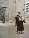 Woman with child in street with can, Egypt, 1946