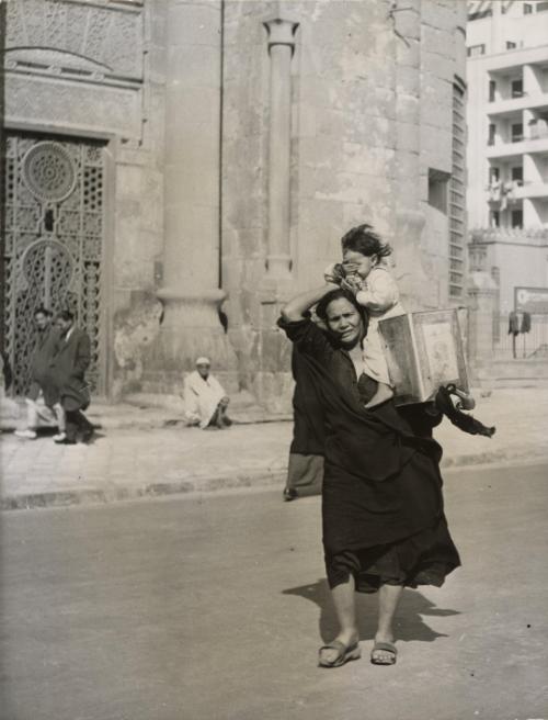 Woman with child in street with can, Egypt, 1946