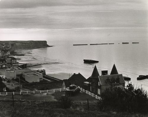 Coastal landscape with World War II tank in yard, England, c. 1960