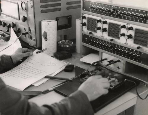 Officer on radio reading Interpol news brief, Lyon, France, c. 1960
