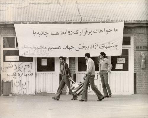 The atmosphere around the U.S. Embassy at Tehran where students have been guarding 100 hostages, including 60 Americans, since November 4. Here students are evacuating garbage from the Embassy in a U.S. Flag, Tehran, Iran, November 12, 1979.